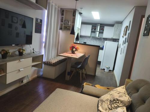 un piccolo soggiorno con un tavolo e una cucina di Apartamento aconchegante 10 minutos de Penedo a Resende