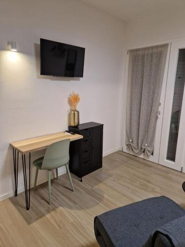 a living room with a desk and a television on the wall at B&B Casa Tassoni in Maranello