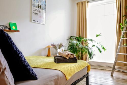 a room with a bed with a yellow blanket at Designer Flat in Bethnal Green in London