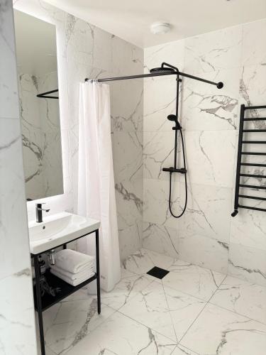 a white bathroom with a shower and a sink at Central Stay Hofn in Höfn