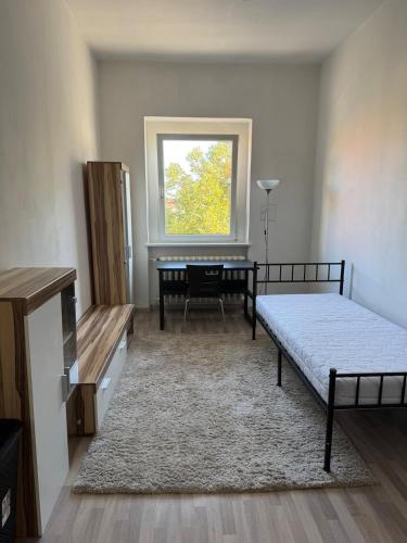 a bedroom with a bed and a table and a window at Wohnen inklusive Fitness & Wellness in Dessau