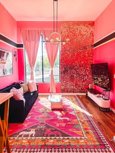 a living room with pink walls and a black couch at Dolly's Glam Getaway - Glittering Gem Near Broadway in Nashville