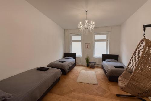 a bedroom with three beds and a chandelier at Offenbach 200 m2 9 Betten O2 EG in Offenbach