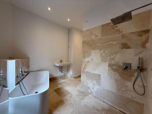 a bathroom with a bath tub and a sink at Offenbach 200 m2 9 Betten O2 EG in Offenbach