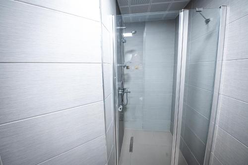 a shower with a glass door in a bathroom at 32 Floor 1BR Apt with Spa & Fitness in Skopje