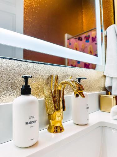 a bathroom with a sink with a gold faucet at Dolly's Art Deco - Luxe Stay Near Broadway in Nashville