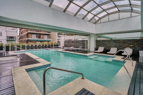 a large swimming pool with a glass ceiling at Quartier Libertador Panoramico Vista al Rio in Buenos Aires