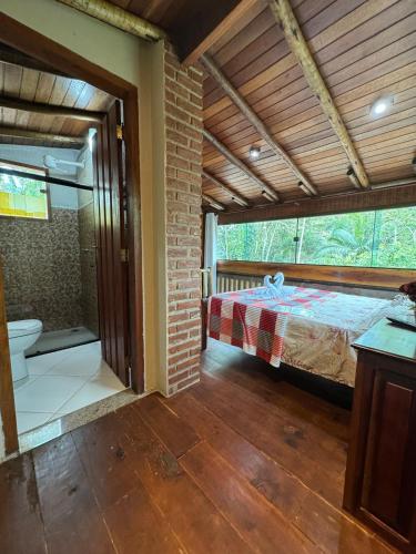 a bedroom with a bed and a bathroom at Pousada Marcondes in Paraty