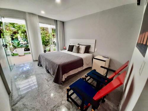a bedroom with a bed and a red chair at Vila Mar Hotel in Olinda