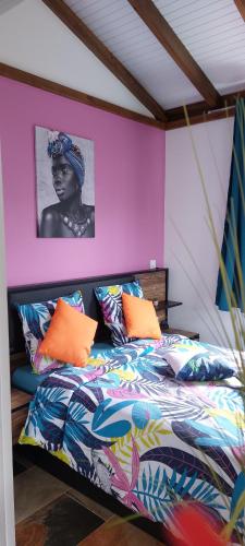 a bedroom with a bed with colorful pillows at Bungaillou in Lamentin