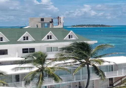 サン・アンドレスにあるApartamentos Commodore Bay Clubの海の前にヤシの木が植えられた建物