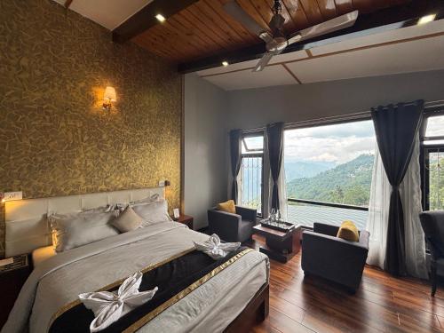 a bedroom with a large bed and a large window at Sood's Himalayan Vista in Kalimpong