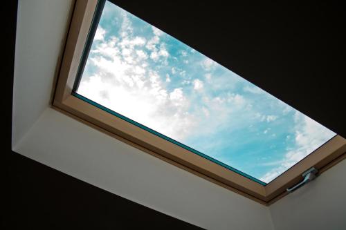 a skylight window in a room with the sky at Hostel Karisma in Bacău