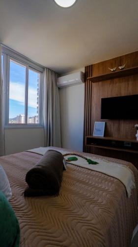 a bedroom with a large bed with a pillow on it at Novíssimo! Na 2ª quadra do mar! in Vila Velha