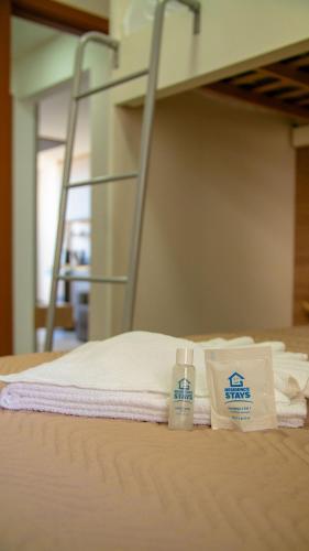 a hospital bed with towels and a bottle of medicine at Novíssimo! Na 2ª quadra do mar! in Vila Velha