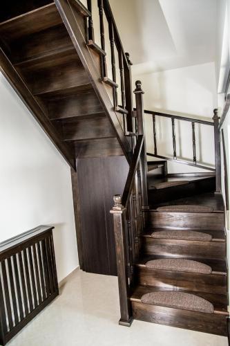 a wooden staircase with wooden railings in a house at Hostel Karisma in Bacău