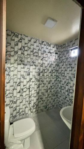a bathroom with a toilet and a sink and a tub at Pousada Amorim in Frecheirinha