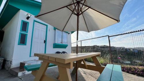 a picnic table with an umbrella in front of a house at Cabañas Coquimbo in Coquimbo