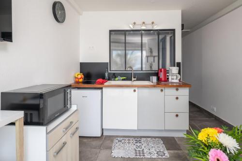 a kitchen with white cabinets and a sink at Balcon des alizés pieds dans l'eau in Le Gosier