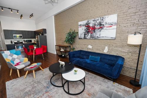 a living room with a blue couch and a brick wall at South Loop 3BR Group Comfort Near Downtown, Grant Park, Soldier Field and McCormick Place in Chicago