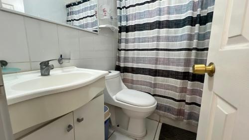 a bathroom with a sink and a toilet and a mirror at Cabañas Coquimbo in Coquimbo