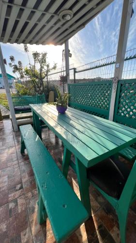 a green picnic table with benches on a patio at Cabañas Coquimbo in Coquimbo