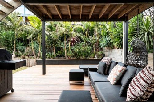 a living room with a couch on a patio at Sweeping Ocean Views Pet Friendly in Torquay