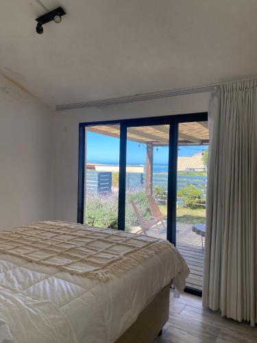 a bedroom with a bed and a view of the ocean at Apartamentos Alborada in La Paloma
