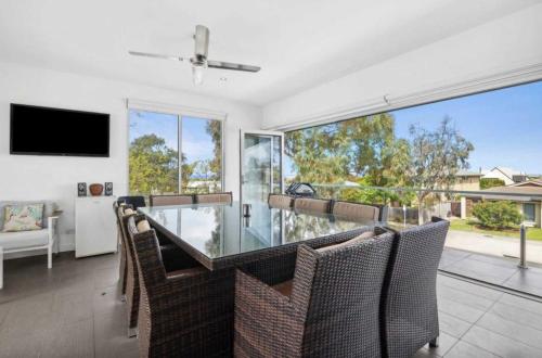 a dining room with a glass table and chairs at Luxury 6 Bedroom Coastal Retreat with Spa & Ocean Views in Torquay