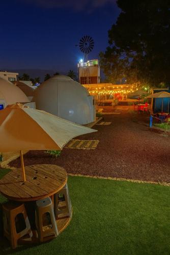 a tent and a table with an umbrella on the grass at Iglú Sparrow vista al cielo in Barra de Navidad