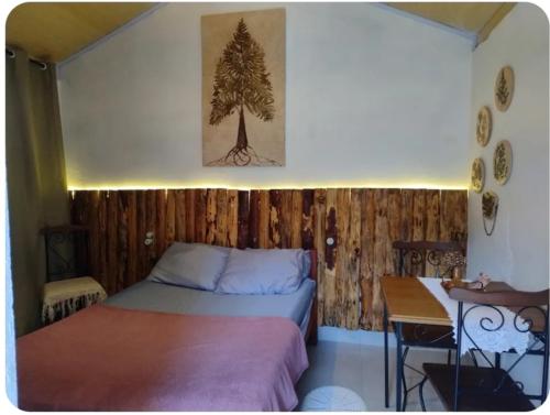 a bedroom with two beds and a table and a desk at Recanto da paz in Monte Verde