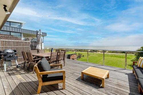 a deck with a table and chairs and a grill at Absolute Waterfront Escape Deck & Games Room in Portarlington