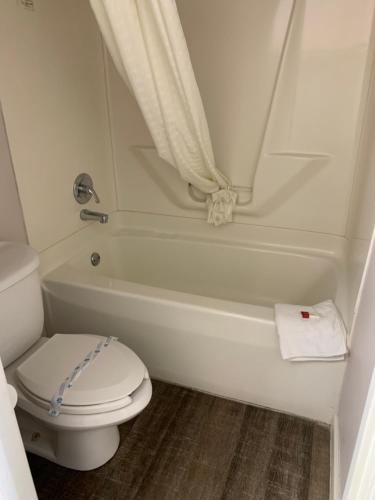 un baño con inodoro y bañera en Days Inn by Wyndham Clinton, en Clinton