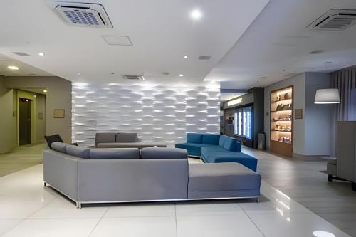 a lobby with blue couches and a table at Apartamento charmoso em Santos ao lado da praia in Santos