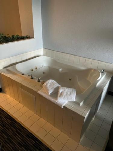 a bath tub with two towels in a bathroom at Lakeside Resort & Conference Center in Houghton Lake