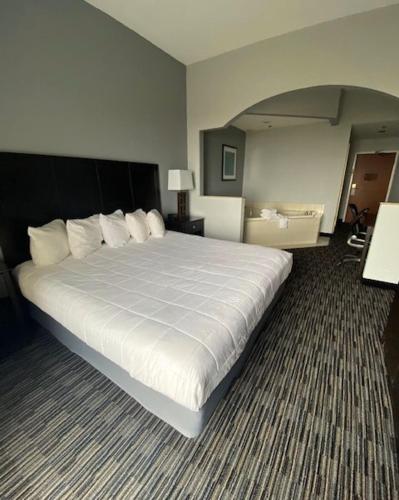 a large white bed in a hotel room at Lakeside Resort & Conference Center in Houghton Lake