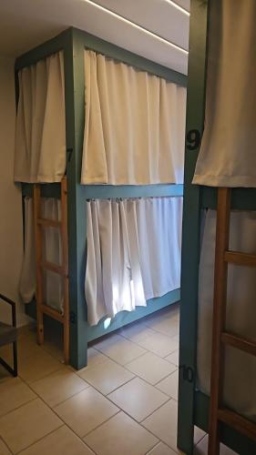 a room with a bed with a curtain and a window at Hostel new way in Sao Paulo