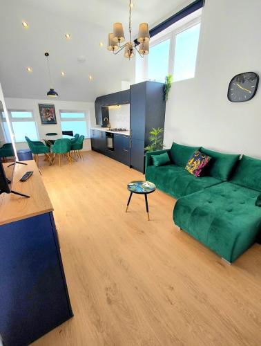 a living room with a green couch and a table at Blue Door Apartments in Dover