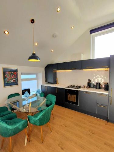 a kitchen with a glass table and green chairs at Blue Door Apartments in Dover