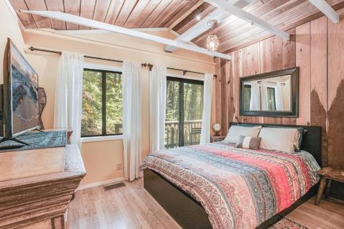una camera da letto con un letto in una stanza con finestre di Norcal Hideaway - Dogs OK a Guerneville