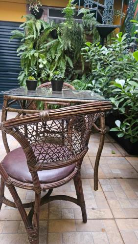 a wicker table and a chair with a table and plants at Hostel new way in Sao Paulo