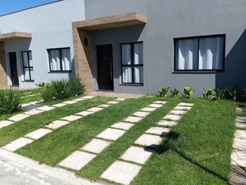 a house with a green lawn in front of it at Loft Noruega 32 AC Garagem Privativa in Jaguarão