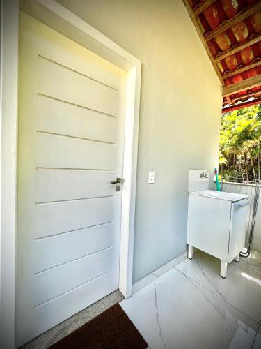 a white door in a room with a sink at Apê das Montanhas com vista e próx centro DM in Domingos Martins