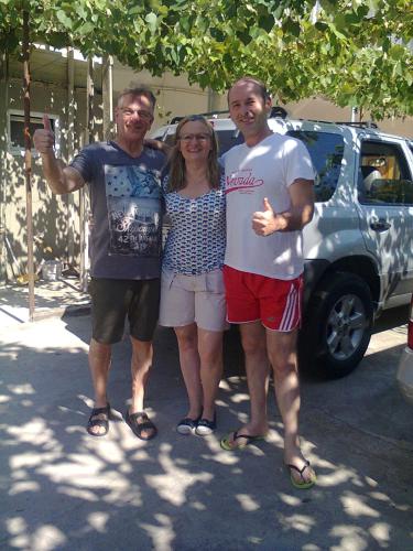 a group of three people standing in front of a car at Giorgi's Homestay in Kutaisi