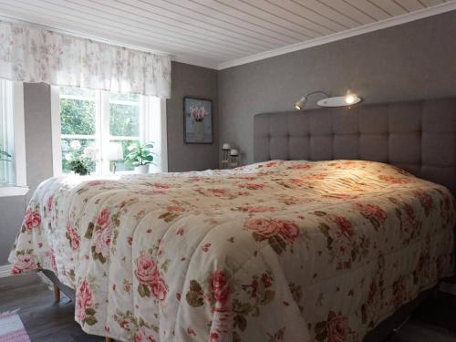 a bedroom with a large bed with a floral bedspread at 6 person holiday home in LYSEKIL in Torgestad