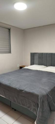 ein Schlafzimmer mit einem großen Bett in einem weißen Raum in der Unterkunft Lindo AP de 2 quartos e vaga de garagem 131 in São Leopoldo