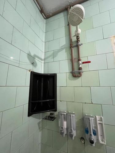 a tiled wall with a television and a fan at Vana Hostel Familiar in Fortaleza