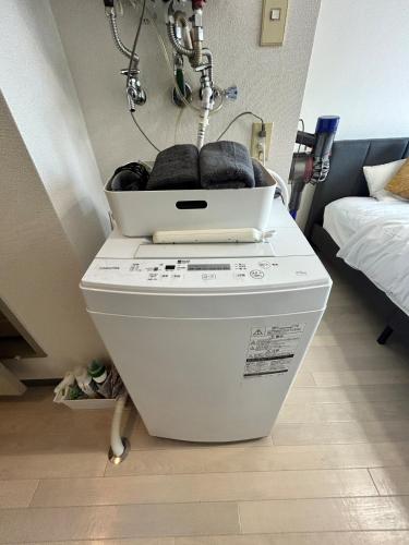 a washing machine with a laptop on top of it at テラ二十四軒 in Sapporo