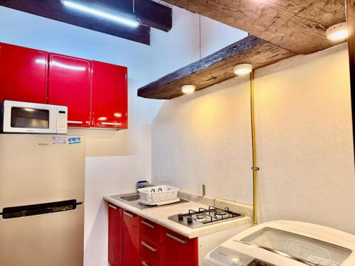 a small kitchen with red cabinets and a white refrigerator at Tizapan 04 NEW 1BE&1BA in Mexico City