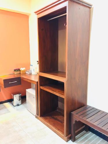 a wooden cupboard with a bench in a room at Royal Rock Sigiriya in Sigiriya